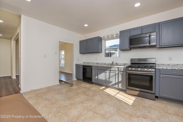 kitchen featuring appliances with stainless steel finishes, plenty of natural light, gray cabinets, and recessed lighting