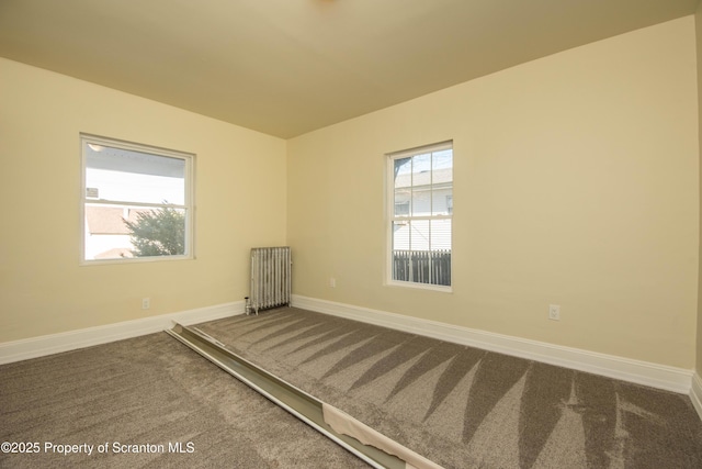 unfurnished room with carpet floors, radiator heating unit, plenty of natural light, and baseboards