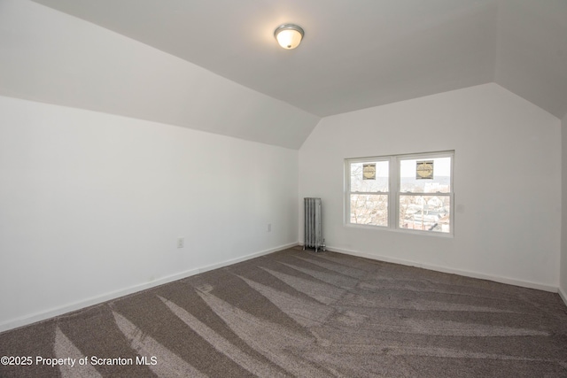 bonus room with baseboards, vaulted ceiling, and dark colored carpet