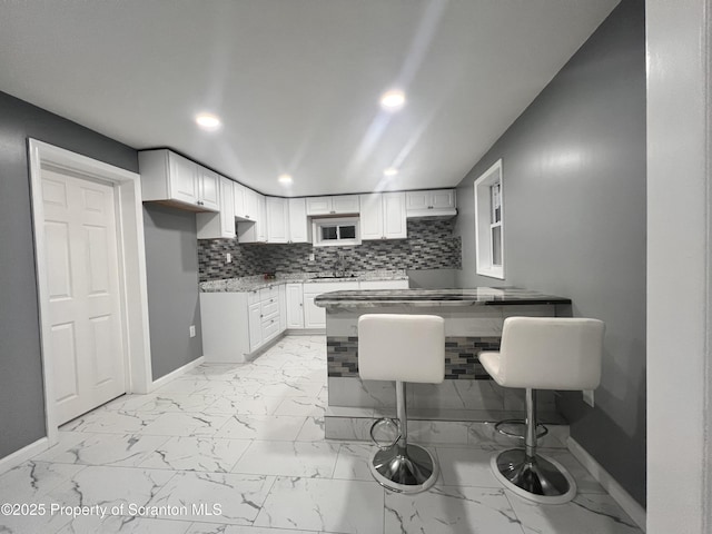 kitchen featuring backsplash and white cabinetry