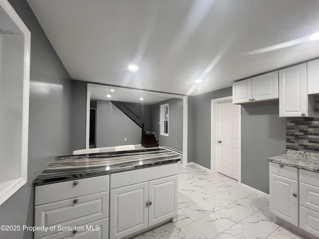 kitchen featuring tasteful backsplash and white cabinetry