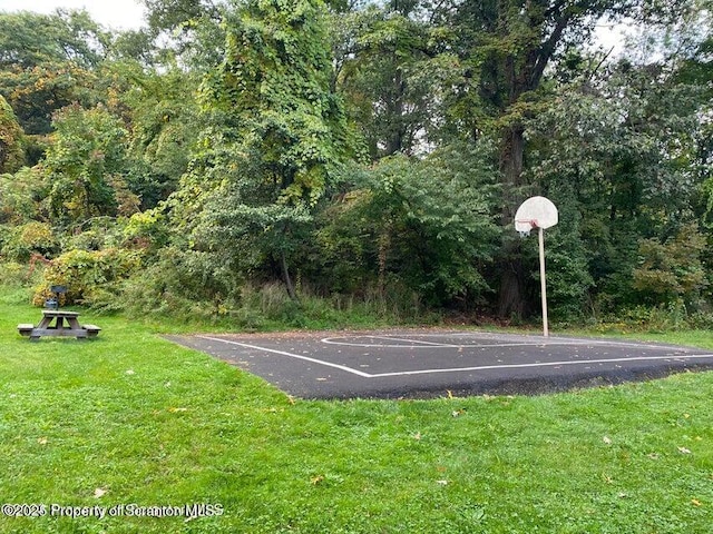 view of sport court with a lawn