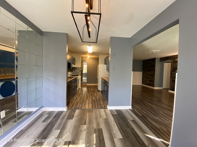 kitchen with white fridge, black dishwasher, dark hardwood / wood-style flooring, and decorative backsplash