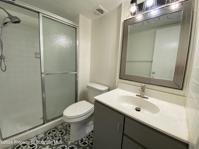 bathroom with vanity, toilet, and a shower with shower door