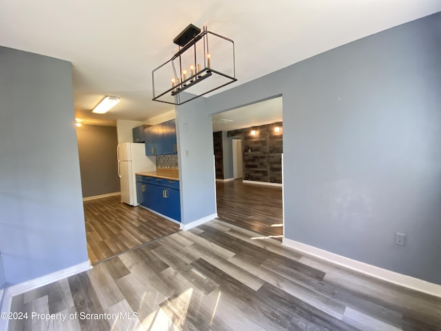 unfurnished living room featuring dark hardwood / wood-style flooring and a notable chandelier