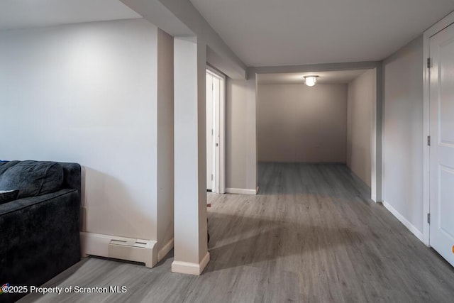 hall featuring baseboards, baseboard heating, and wood finished floors