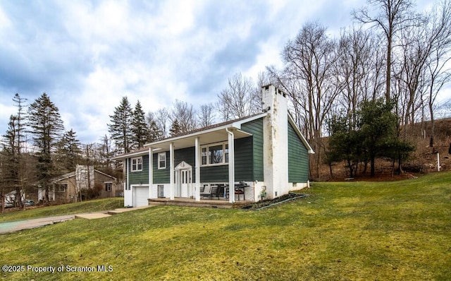 split foyer home with a garage, concrete driveway, a front lawn, and a chimney