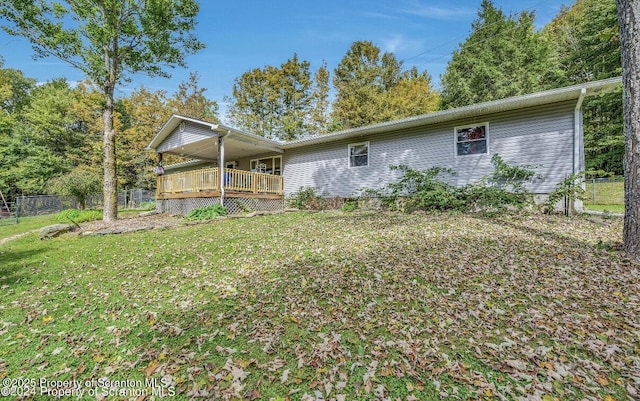 rear view of house featuring a yard and a deck