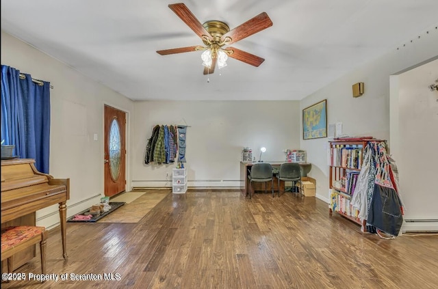 miscellaneous room with ceiling fan, a baseboard radiator, and wood-type flooring