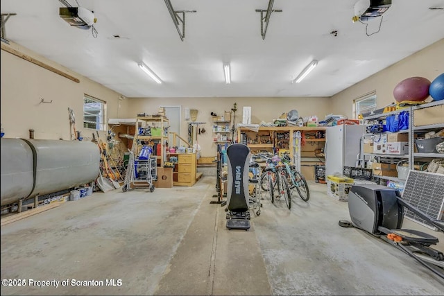 garage with a garage door opener and a workshop area