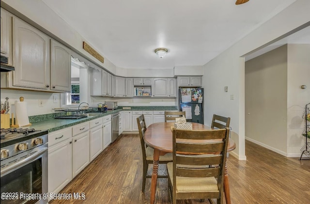 kitchen with hardwood / wood-style flooring, appliances with stainless steel finishes, and gray cabinetry