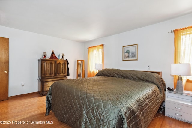 bedroom with baseboards and light wood-type flooring