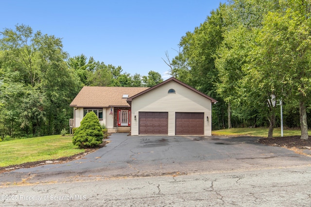 view of front of home featuring driveway, a garage, and a front lawn