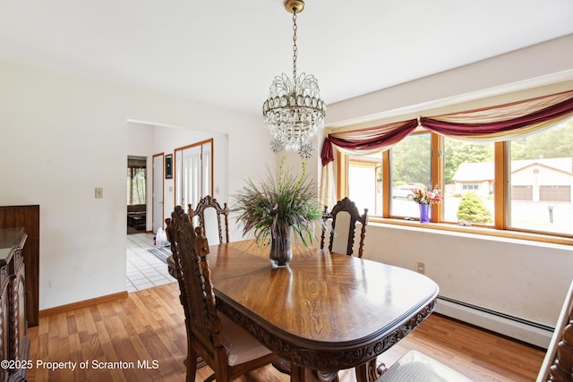 dining area with a baseboard radiator, light wood-type flooring, baseboards, and an inviting chandelier