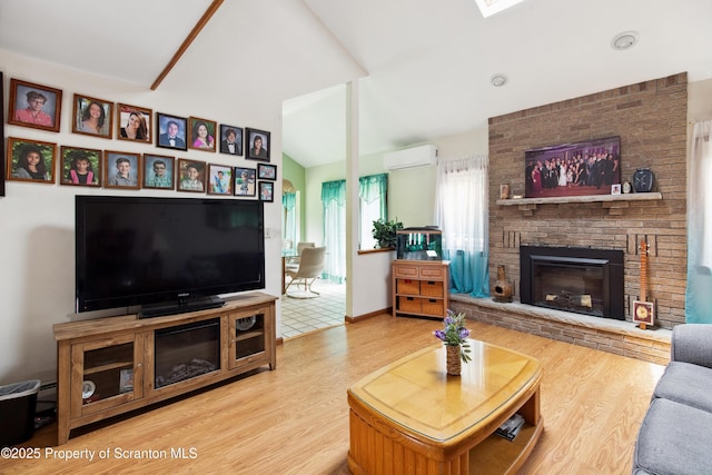 living area with baseboards, a fireplace, wood finished floors, lofted ceiling, and an AC wall unit