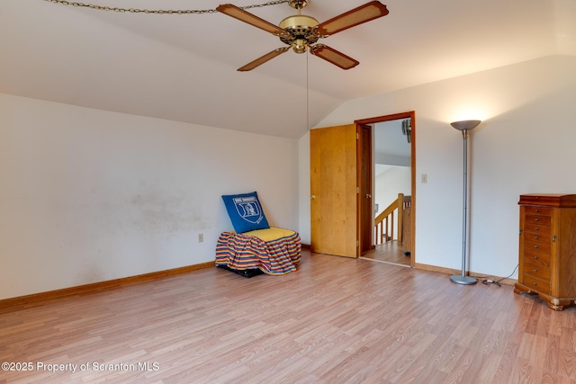 unfurnished room featuring an upstairs landing, lofted ceiling, light wood-style flooring, baseboards, and ceiling fan