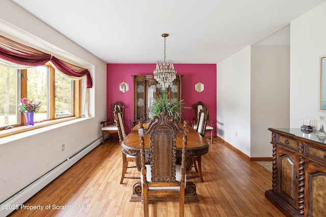 dining room with light wood-type flooring, baseboards, a chandelier, and baseboard heating