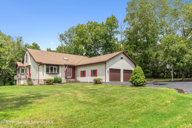 view of front facade featuring a shingled roof, driveway, a front yard, and an attached garage