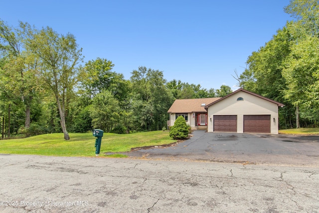 view of front of property featuring driveway, an attached garage, and a front lawn
