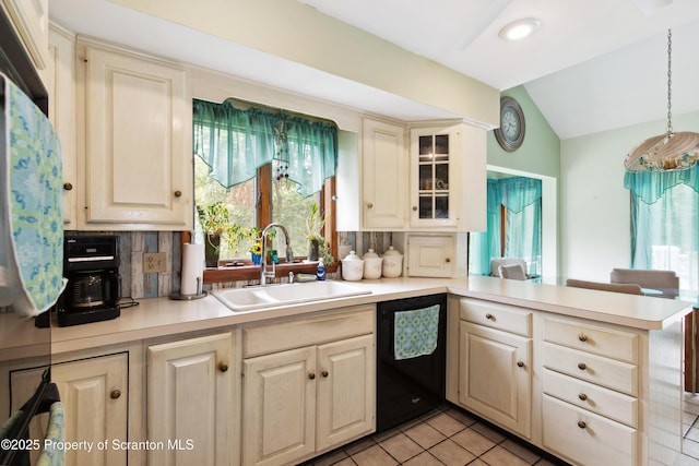 kitchen featuring light countertops, black dishwasher, tasteful backsplash, a sink, and vaulted ceiling