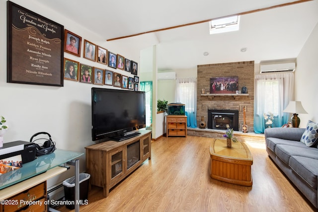 living area with plenty of natural light, an AC wall unit, and wood finished floors