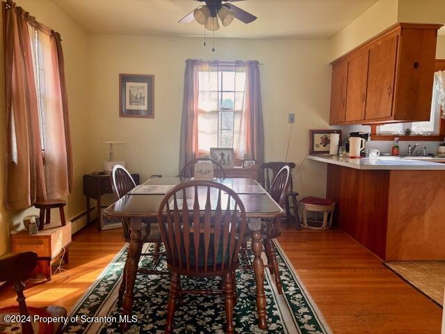 dining area featuring light wood finished floors and a ceiling fan