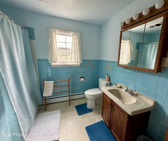 bathroom featuring wainscoting, toilet, a baseboard radiator, vanity, and tile walls