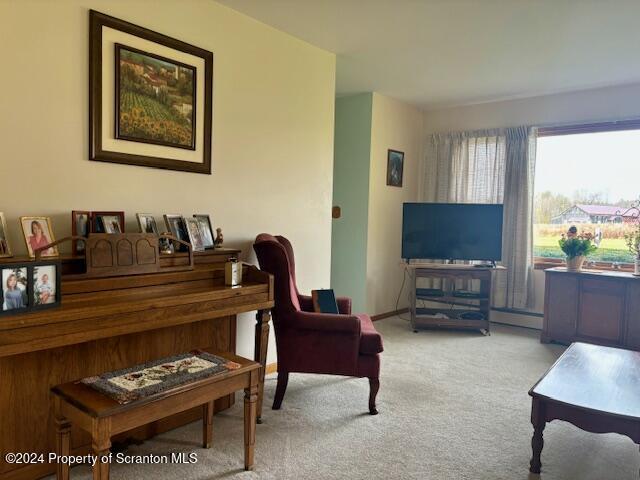 living area featuring carpet and baseboards