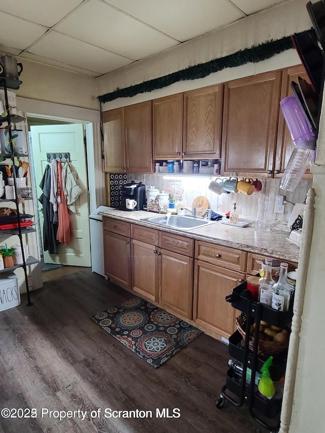 kitchen with a drop ceiling, sink, backsplash, and dark hardwood / wood-style floors