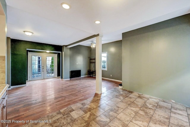 unfurnished living room with french doors and ceiling fan