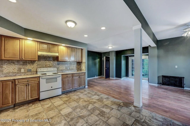 kitchen featuring radiator heating unit, white electric stove, and decorative backsplash