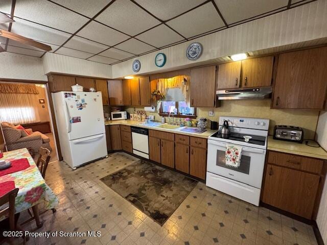 kitchen featuring a drop ceiling, sink, and white appliances