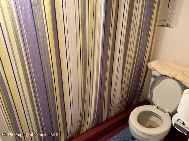 bathroom featuring toilet and a shower with shower curtain