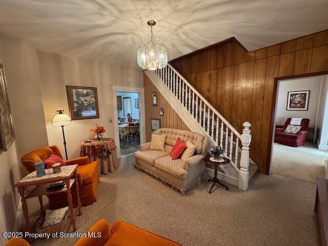 living room with wooden walls and a notable chandelier