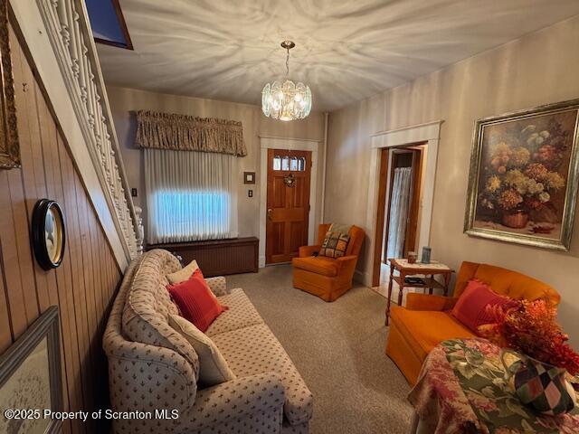 living room with an inviting chandelier and carpet floors