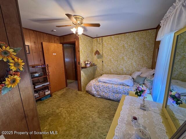 carpeted bedroom featuring crown molding and ceiling fan