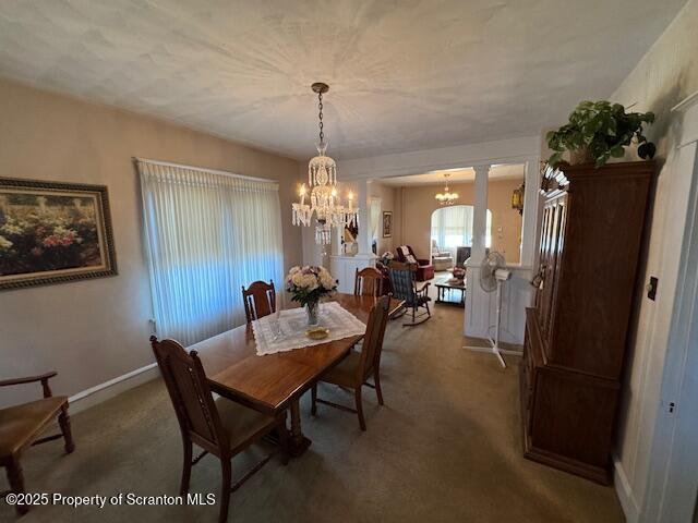 dining room with an inviting chandelier and dark carpet