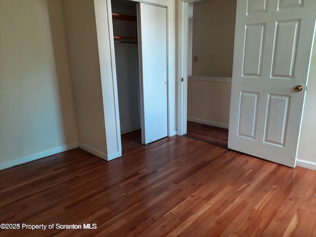 unfurnished bedroom with dark hardwood / wood-style flooring