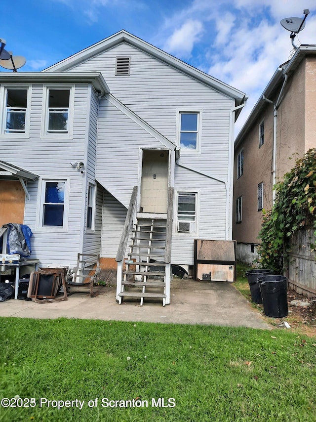 back of property featuring a lawn and a patio