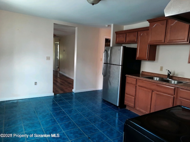 kitchen featuring dark tile patterned flooring, sink, stainless steel fridge, and black electric range oven