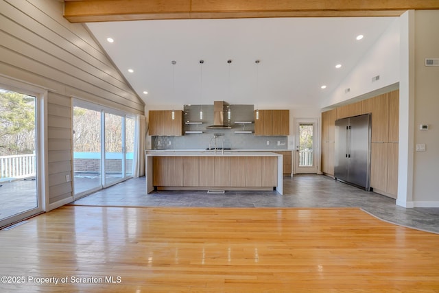 kitchen featuring tasteful backsplash, light countertops, light wood-style flooring, high vaulted ceiling, and modern cabinets