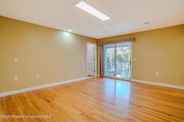 unfurnished room with light wood-type flooring and baseboards