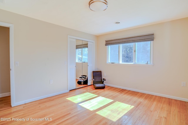 spare room with baseboards and hardwood / wood-style flooring