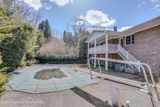 view of pool with central air condition unit, a patio, and stairs