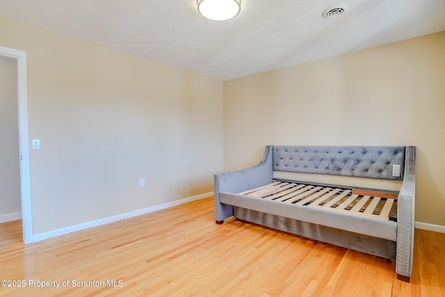 bedroom featuring visible vents, baseboards, and wood finished floors