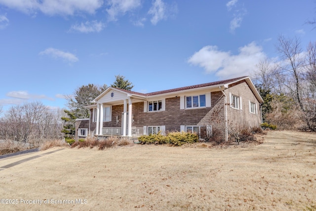 view of front of home with brick siding and a porch