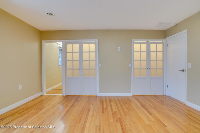 unfurnished room featuring french doors, visible vents, and light wood finished floors