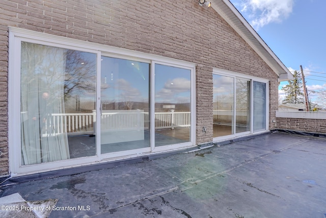 exterior space with brick siding and a patio area