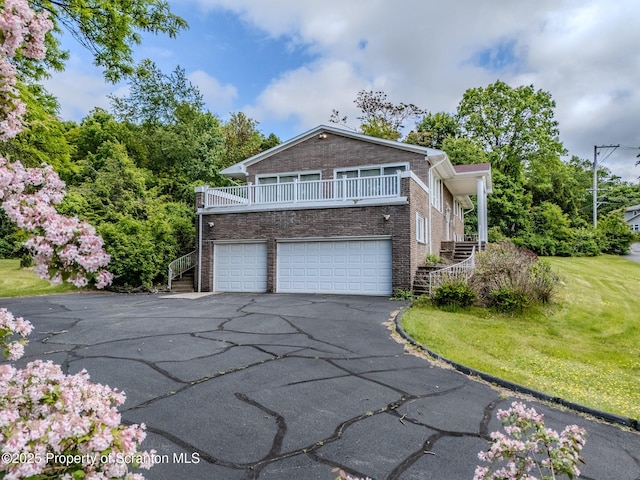 100 Marjorie Dr, Scranton, PA 18505 - view of side of home with stairs, asphalt driveway, a garage, brick siding, and a lawn