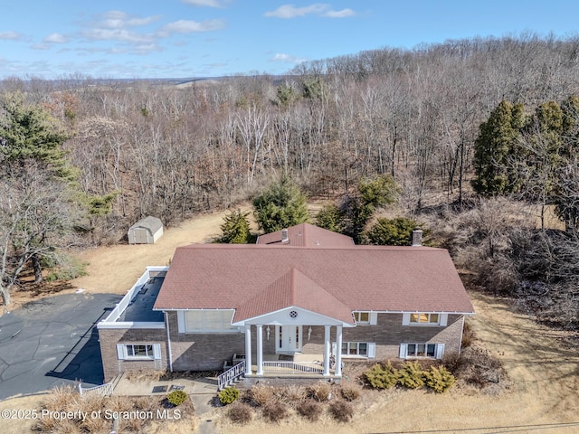 bird's eye view with a wooded view